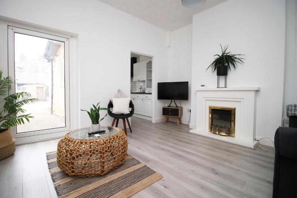 uma sala de estar branca com uma lareira e uma cadeira em Malpas House 4 BR Free street parking em Newport