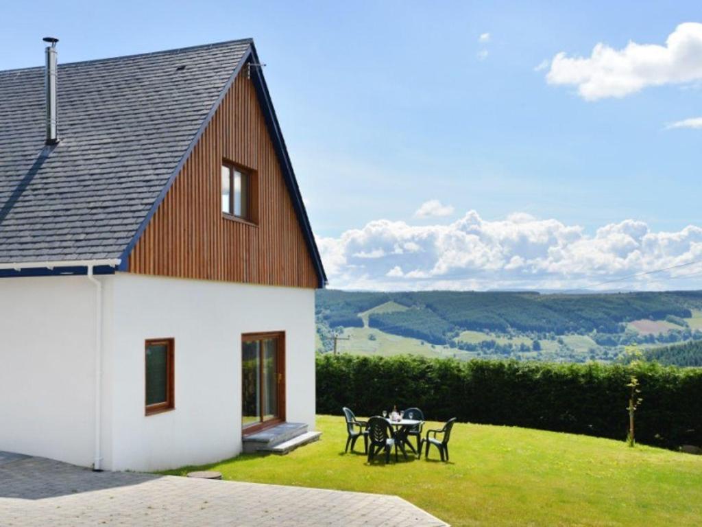 a house with a table and chairs on a lawn at Glen View Lodge in Inverness