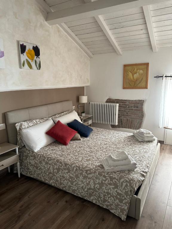 sypialnia z dużym łóżkiem z czerwonymi i niebieskimi poduszkami w obiekcie DOMUS TUSCIA APARTMENTS San Faustino guesthouse w mieście Viterbo