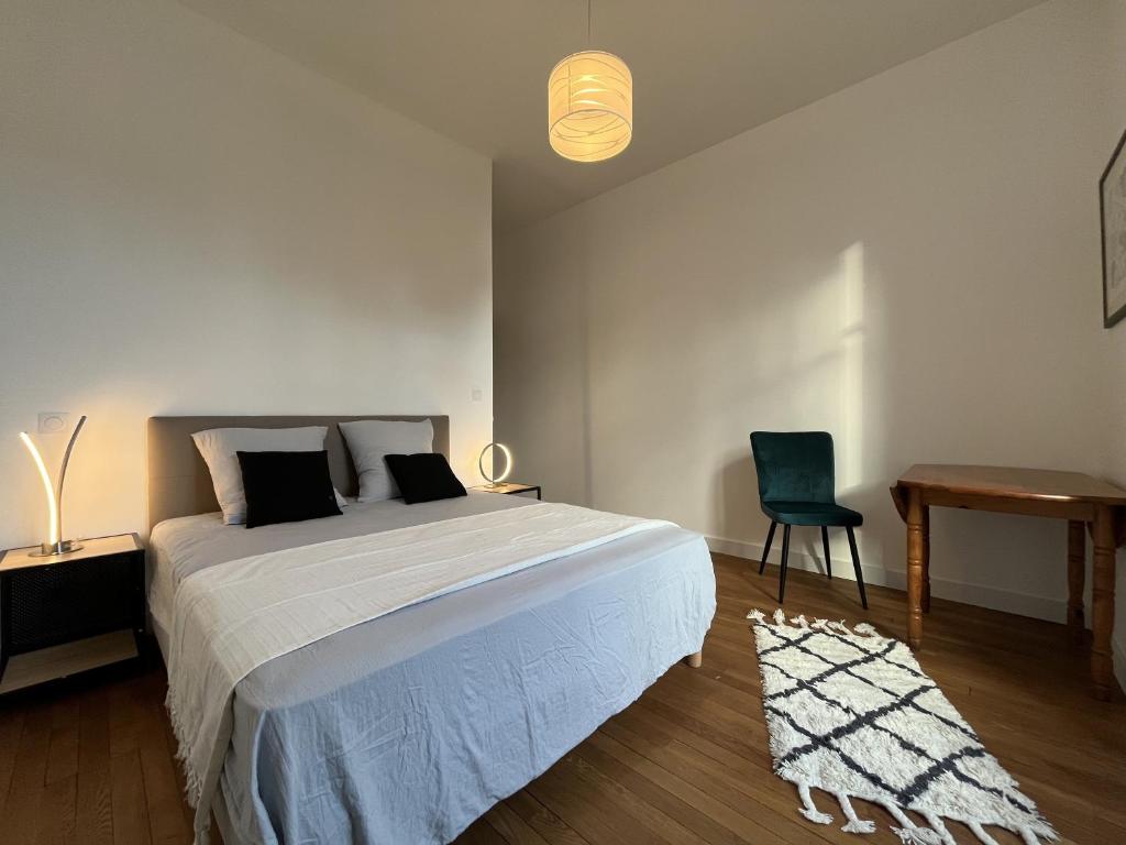 a bedroom with a bed and a desk and a chair at L&#39;aristide in Épinal