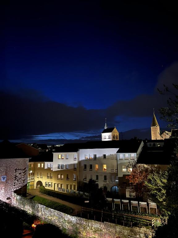a large white building at night with a church at L&#39;aristide in Épinal
