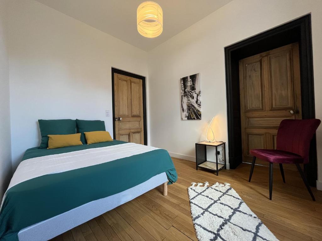 a bedroom with a bed and a chair and a door at L&#39;aristide in Épinal