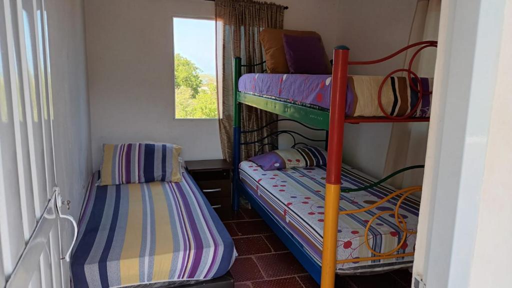 two bunk beds in a room with a window at Cabaña frente a la playa in Tubará