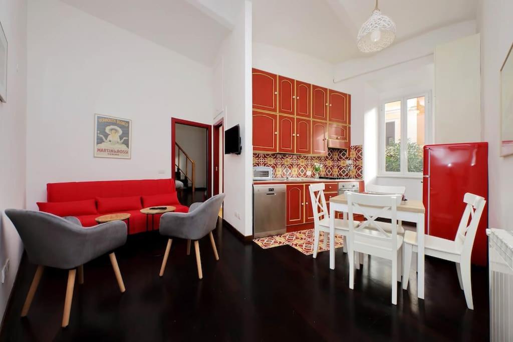 un soggiorno con divano rosso e tavolo di Super appartamento nel cuore del Pigneto a Roma