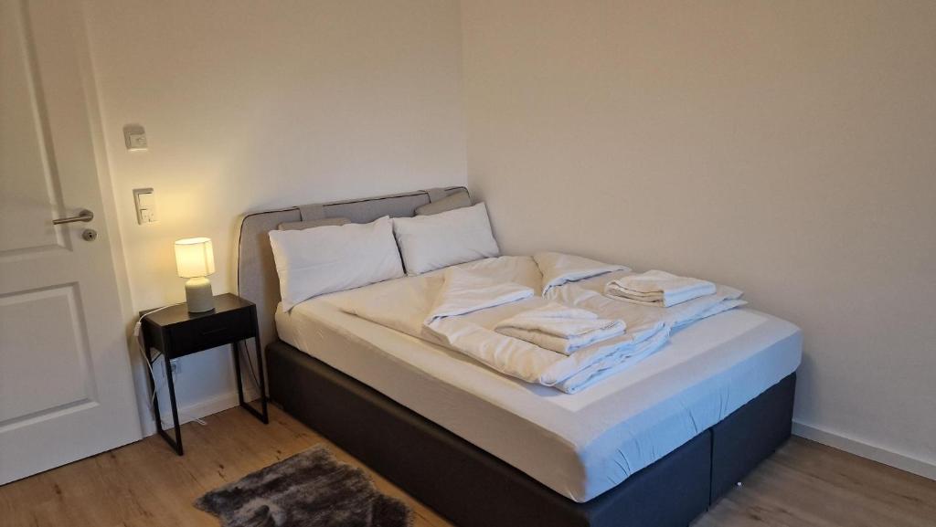 Un pequeño dormitorio con una cama con toallas. en Ferienwohnungen Sisi, en Pöcking