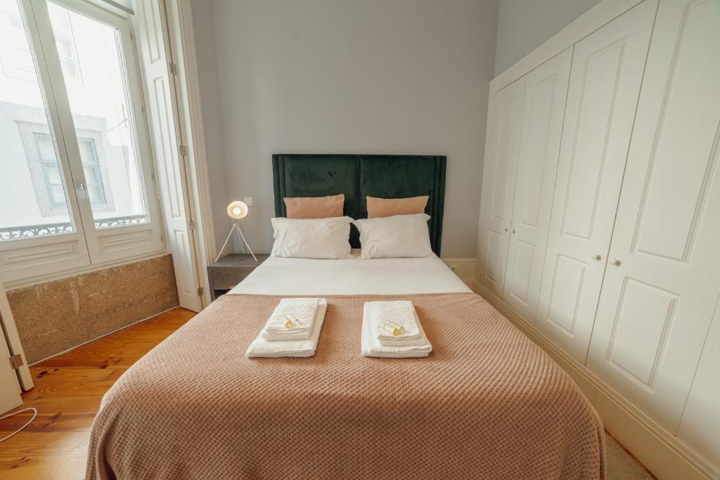 1 dormitorio con 1 cama grande y 2 toallas. en Formosa Deluxe by Hosty en Oporto