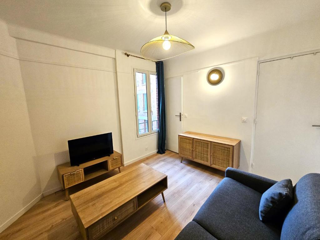 a living room with a couch and a tv at Comme une suite près du métro in Clichy