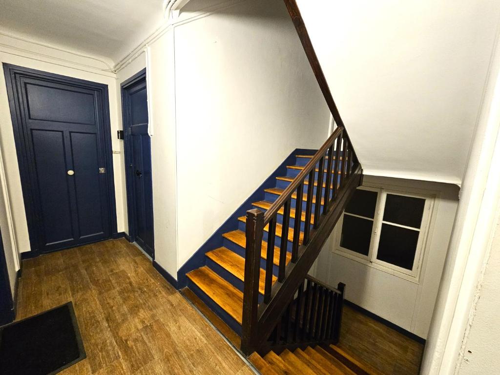a staircase in a house with a blue door at Comme une suite près du métro in Clichy