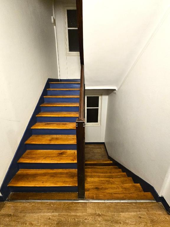 a staircase in a building with blue stairs and a door at Comme une suite près du métro in Clichy