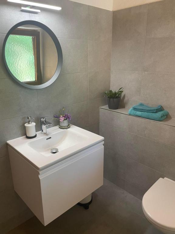 bagno con lavandino bianco e specchio di Naturetouch a Steinberg am Rofan