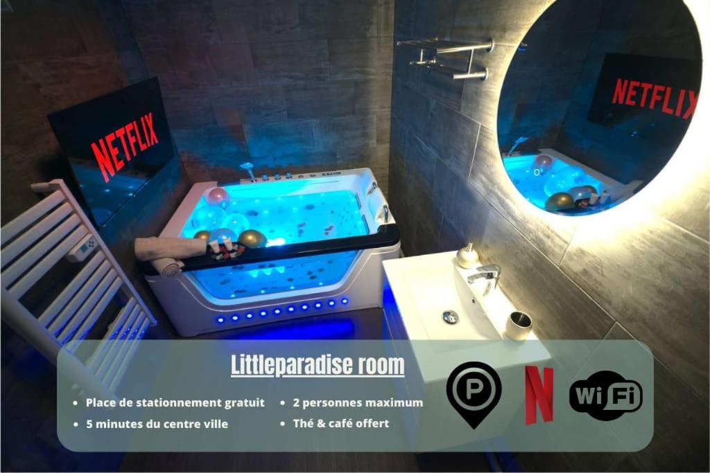 ein Badezimmer mit einer Badewanne und einem Waschbecken mit einem Spiegel in der Unterkunft Littleparadise jacuzzi à 5 minutes du centre ville in Mulhouse