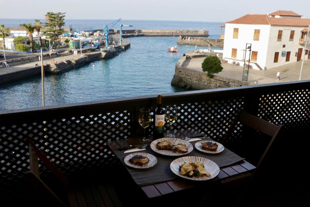 a table with plates of food on a balcony overlooking a river at Marina Suites Tenerife in Puerto de la Cruz