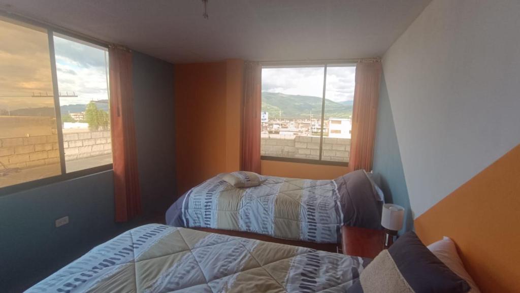 1 dormitorio con 2 camas y ventana en LULU HOUSE, en Machachi