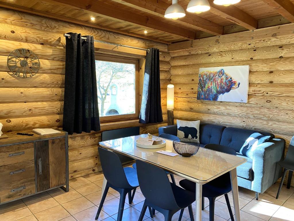 a dining room with a table and blue chairs at L'OURSBLANC Chalet en rondins in La Bresse