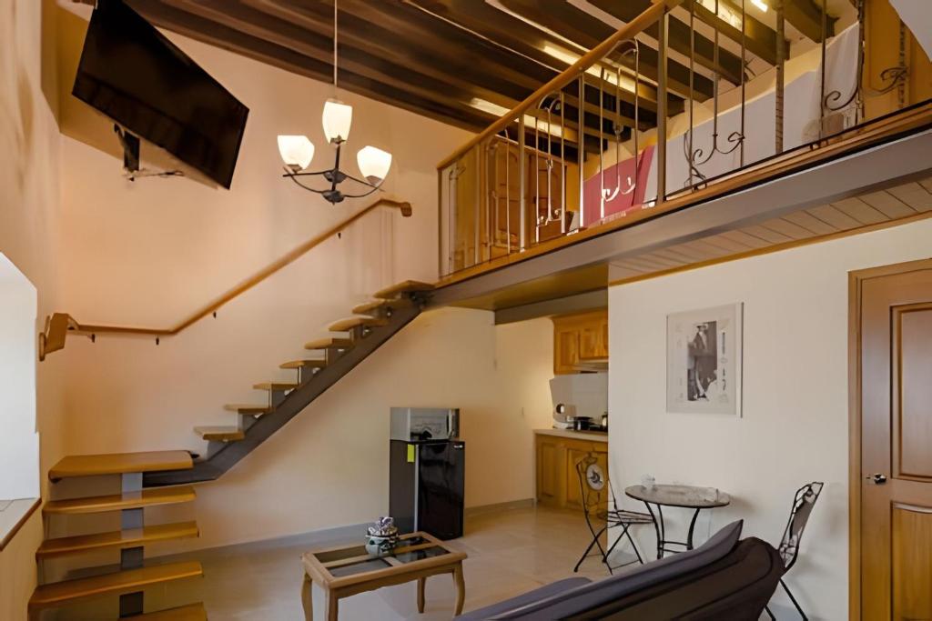 una sala de estar con una escalera en una casa en AC Loft studio gran ubicación en el centro en Querétaro