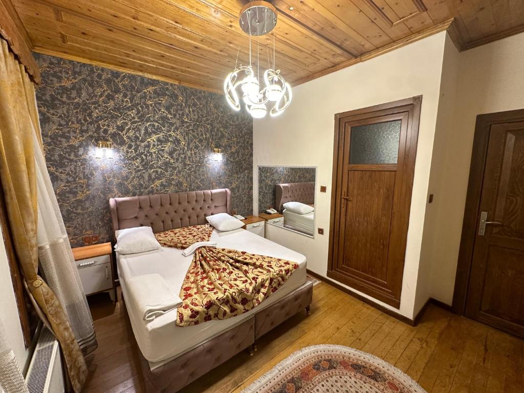 a bedroom with two beds and a chandelier at Gür Royal Suit Aparts in Istanbul