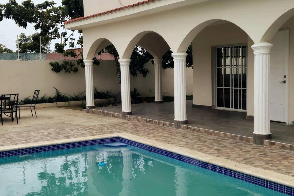 una piscina frente a una casa en Villa Familiar con Piscina cerca Av Ecológica, en La Ureña