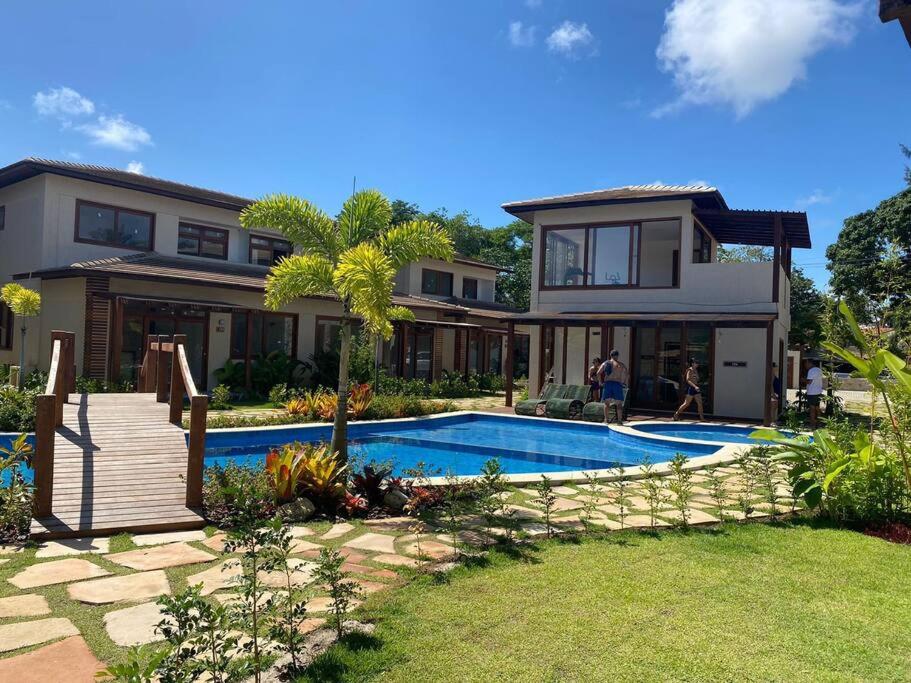 una casa con piscina frente a una casa en Apartamento 110 Viva Barra, en Maraú