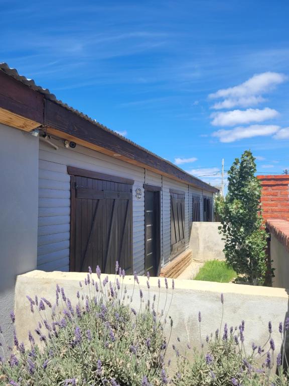 une maison avec une clôture devant elle dans l'établissement Cabañas "El Ancla", à Puerto San Julian