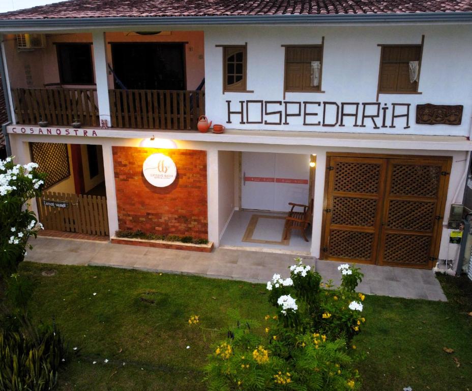 a hotel with a sign on the front of a building at Hospedaria Cosanostra in Itaúnas