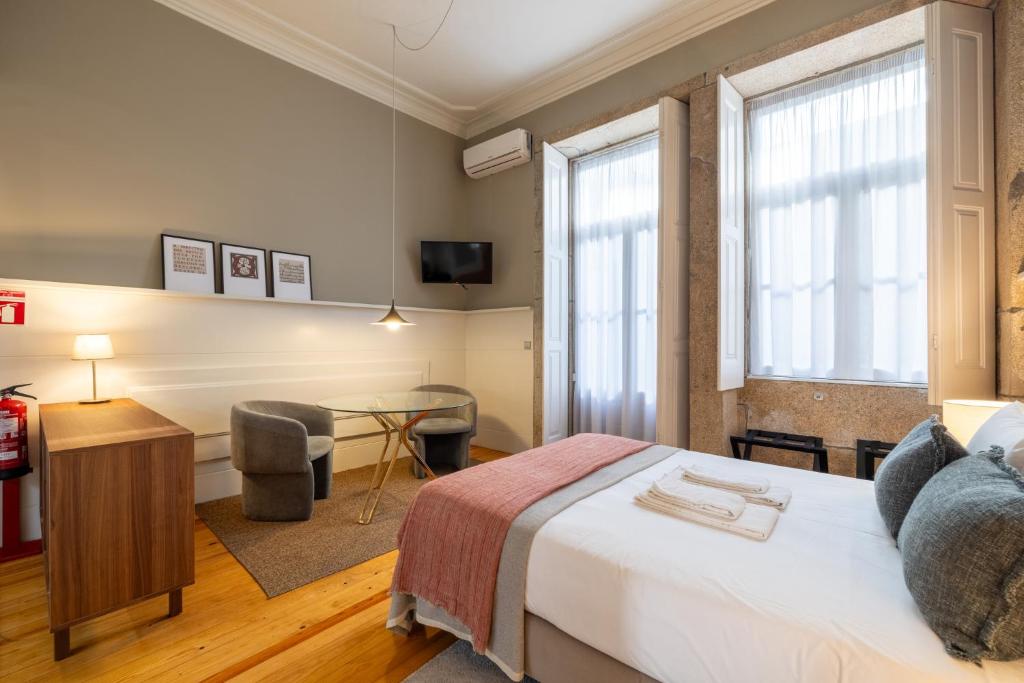 - une chambre avec un lit, un bureau et une chaise dans l'établissement Casa do Ofício - Livreiro, à Porto