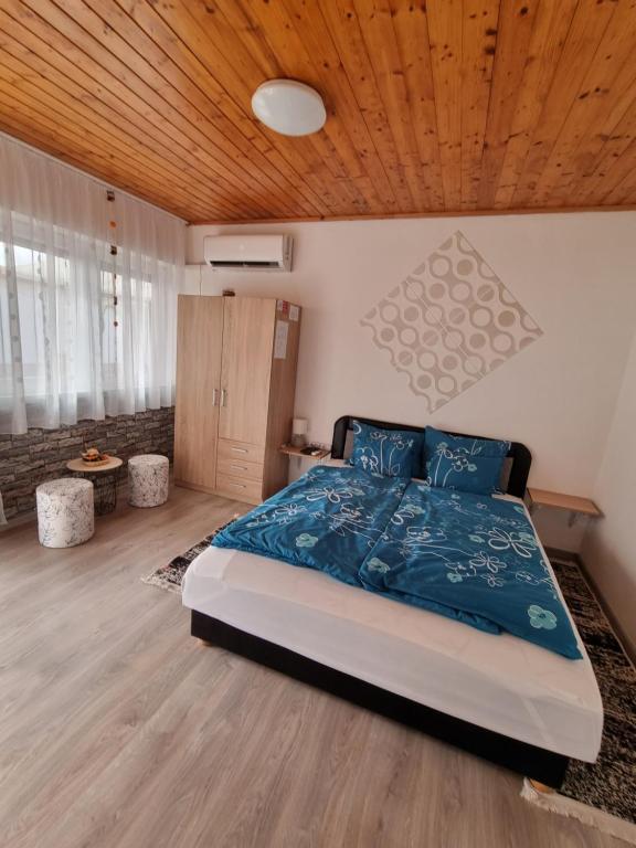 ボガーチにあるNapfény Apartmanの木製の天井が特徴のベッドルーム1室(ベッド1台付)