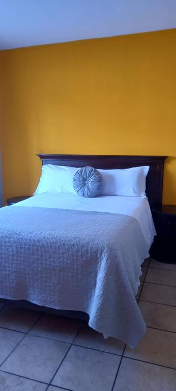 1 dormitorio con cama blanca y pared amarilla en Platinum gem in the City of Rustenburg en Rustenburg
