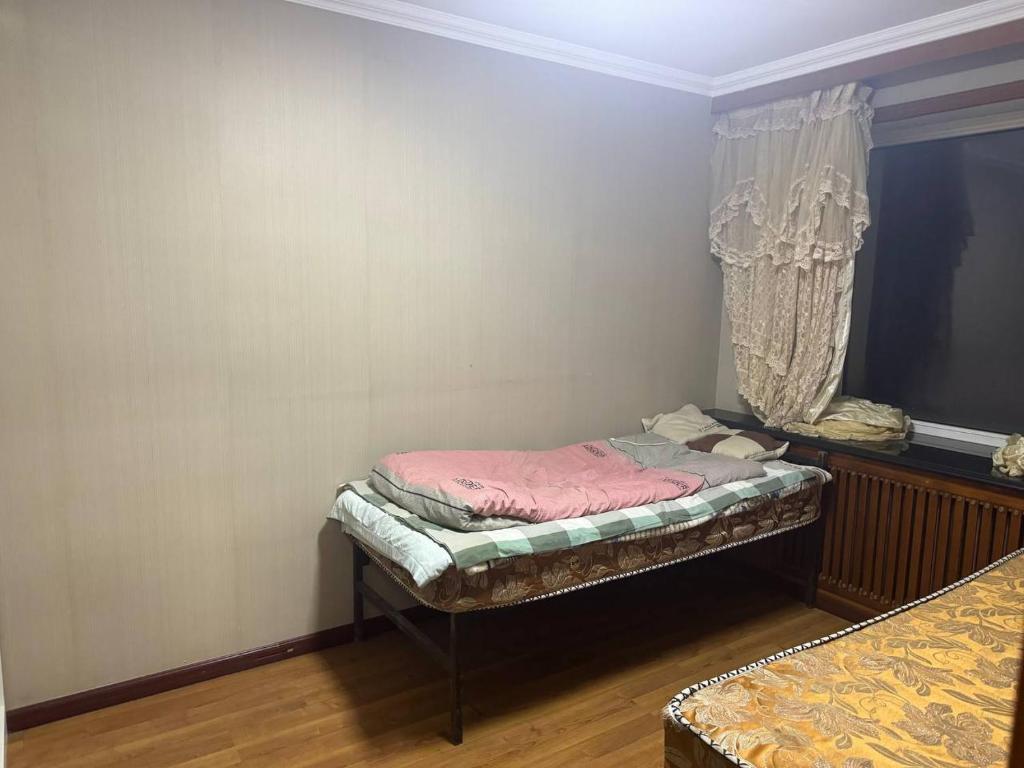 Habitación pequeña con 2 camas y ventana en 九九煮熟 en Macao