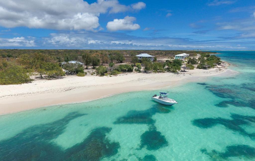 a small boat in the water on a beach at Barbuda Cottages in Codrington Village