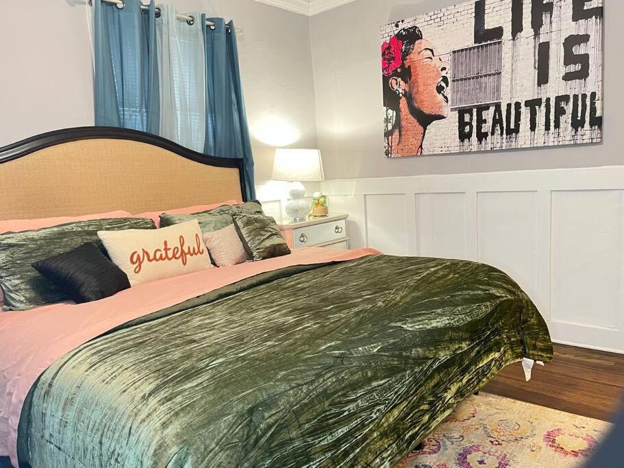 a bedroom with a large bed and a poster on the wall at Cozy Home in the Heart of Jackson/UMMC Hospital in Jackson