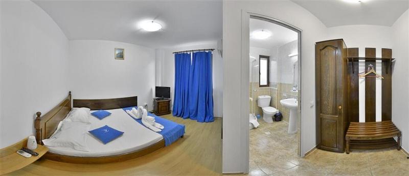 1 dormitorio con 1 cama grande y baño en Hanul Pescarilor, en Mila Douăzeci şi Trei