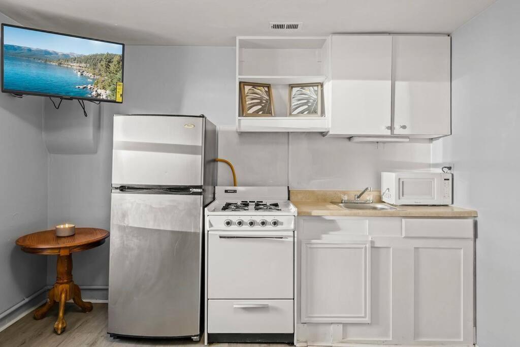a white kitchen with a refrigerator and a stove at Charming retro property! in Sparks