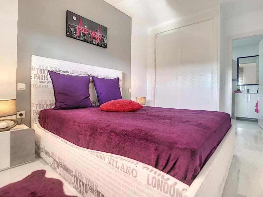 a bedroom with a large bed with purple sheets and purple pillows at Modern apartment Bodrum in Bodrum City