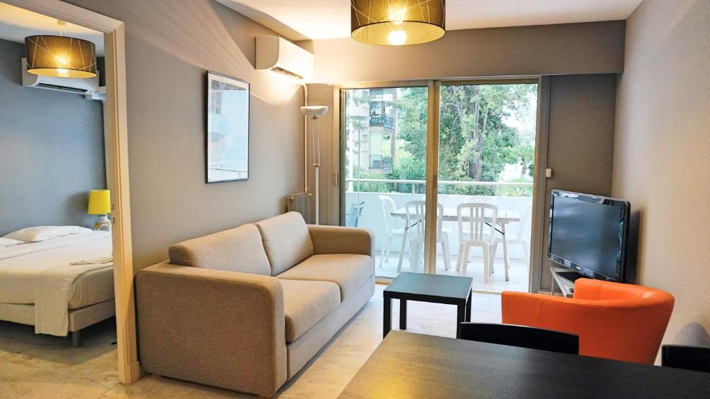 un salon avec un canapé, un lit et une télévision dans l'établissement Proche Croisette, T2 avec terrasse, By Palmazur, à Cannes