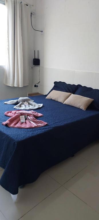 a bed with blue sheets and towels on it at Apê Aconchegante in Recife