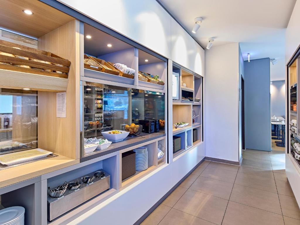 a kitchen with a display case filled with food at B&B Hotel Dortmund-City in Dortmund