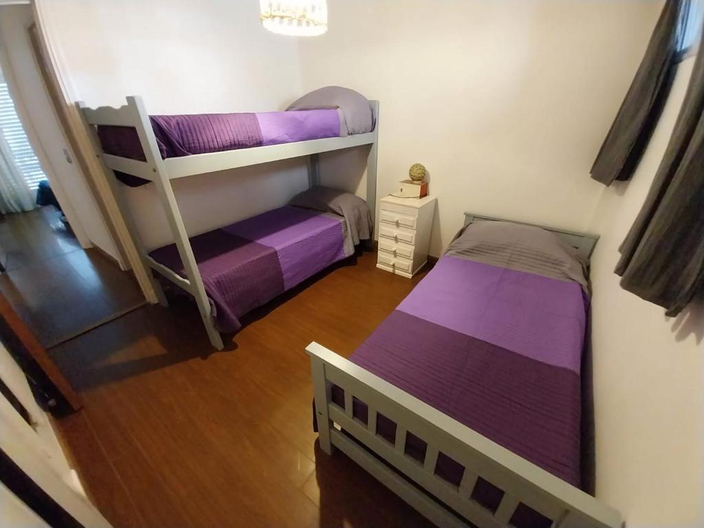2 letti a castello in una piccola camera con lenzuola viola di Playa Grande a Mar del Plata