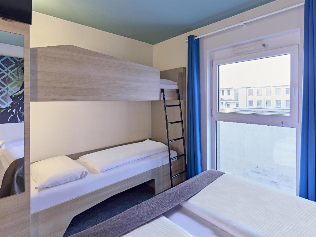 two bunk beds in a room with a window at B&B Hotel Dortmund-City in Dortmund