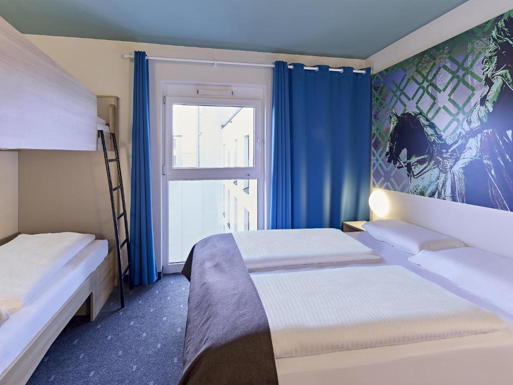 a hotel room with two beds and a window at B&B Hotel Dortmund-City in Dortmund