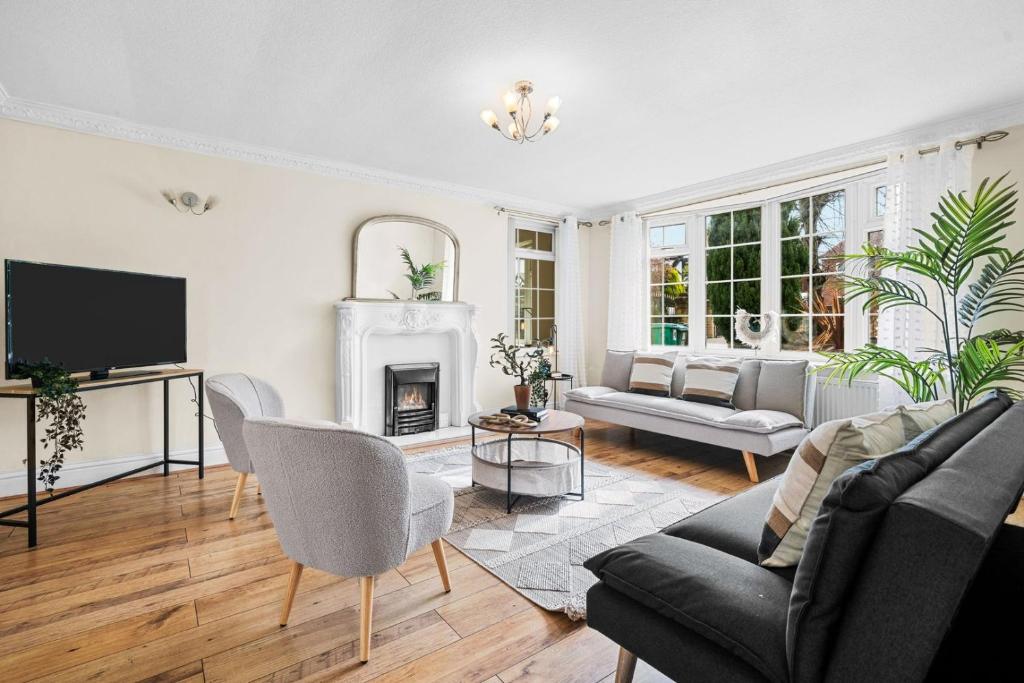 a living room with a couch and a fireplace at Bramcote Lane Spacious 5 BR House in Nottingham