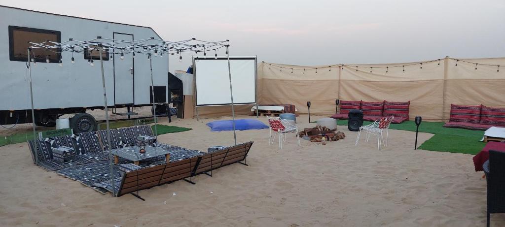 a tent with chairs and a stage in the sand at RVS Caravan Desert Resort Dubai in Hunaywah