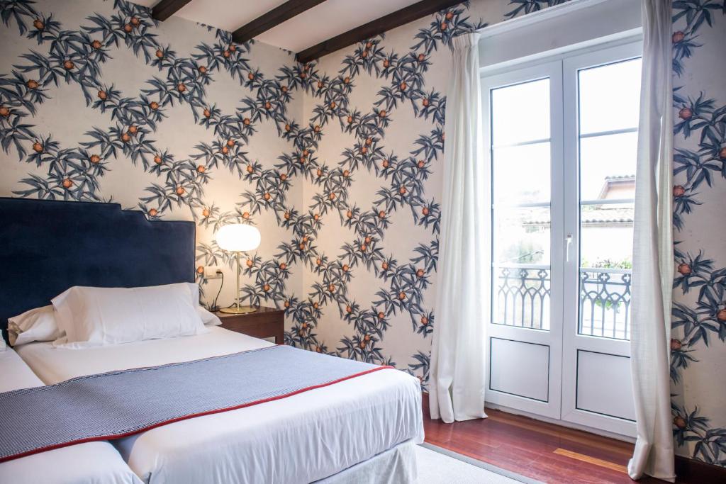 a bedroom with a bed and a window and a door at Hotel A Casa Do Rio in Padrón