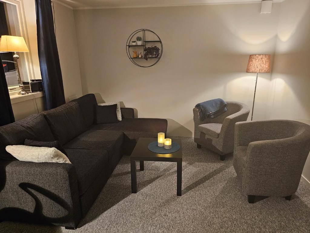 sala de estar con sofá y silla en Leilighet, en Porsgrunn