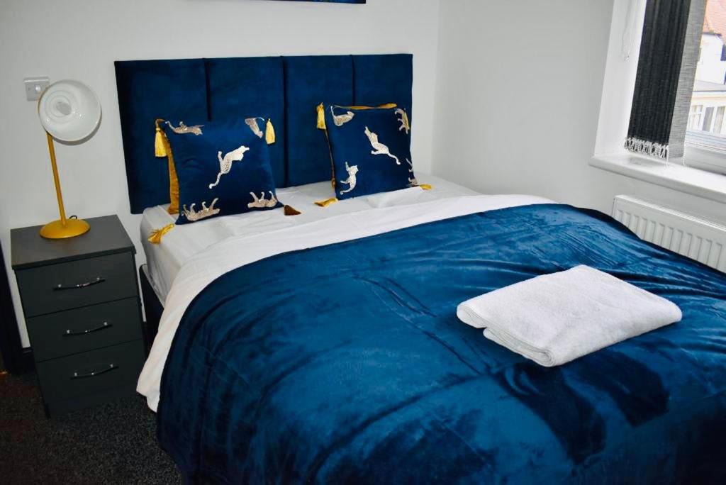 - une chambre avec un lit bleu et une couverture bleue dans l'établissement Beeston House 3 BR and FREE Parking, à Beeston