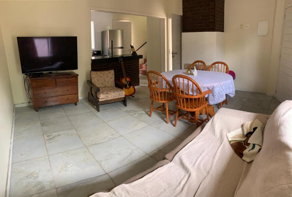 a living room with a table and a tv at Apartamento Praia da Cal in Torres