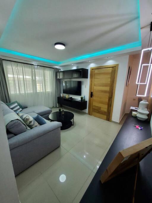 ein Wohnzimmer mit einem Sofa und einem Tisch in der Unterkunft Cómodo Apartamento en San Isidro in Mendoza