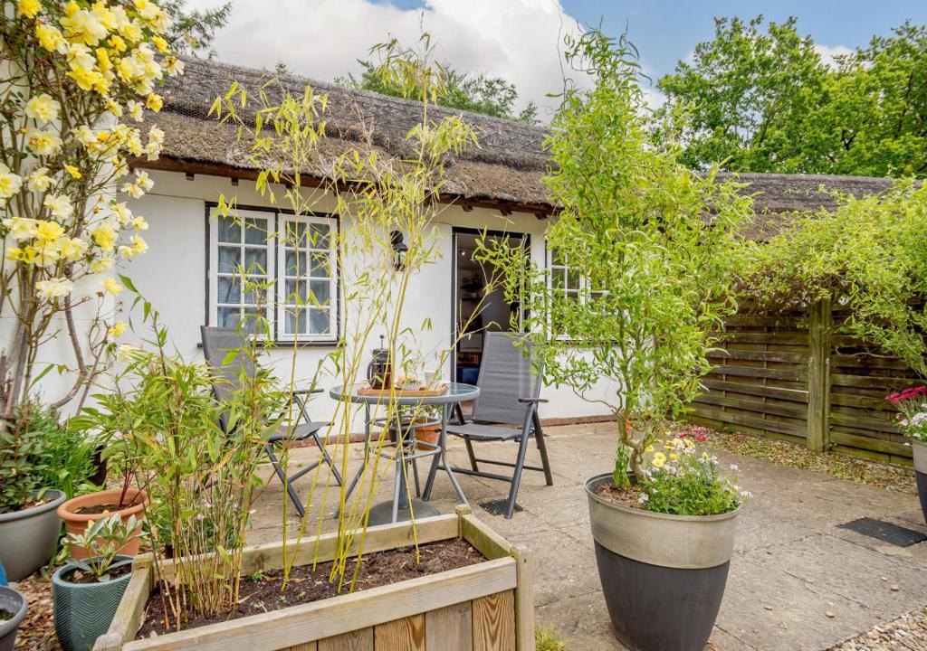 a cottage with a table and chairs in a garden at Half Moon Cottage in West Runton