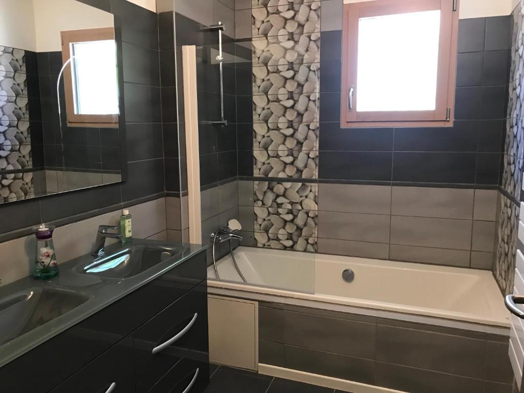 ein Badezimmer mit Badewanne und Waschbecken in der Unterkunft Villa l'Amoureuse 3 in Saint-Paul-le-Jeune