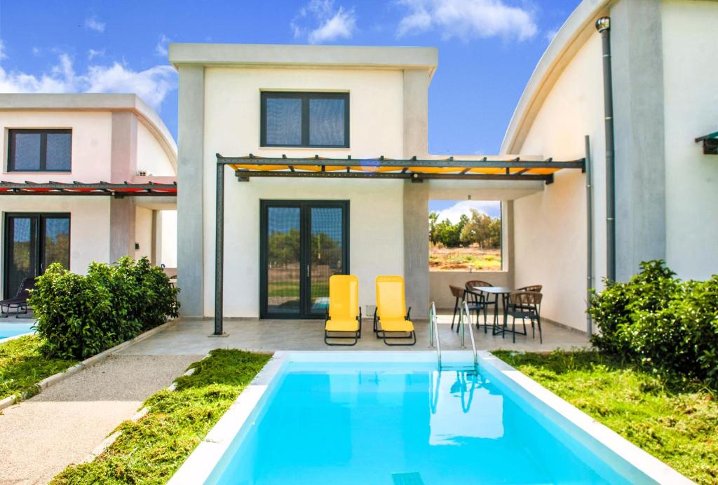 a house with a swimming pool in front of a house at Aurora Suites in Nea Fokea