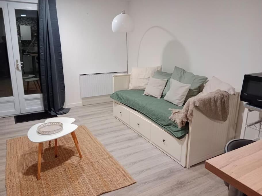 ein Wohnzimmer mit einem Sofa und einem Tisch in der Unterkunft La Salicorne, maison d'hôtes. in Brévands